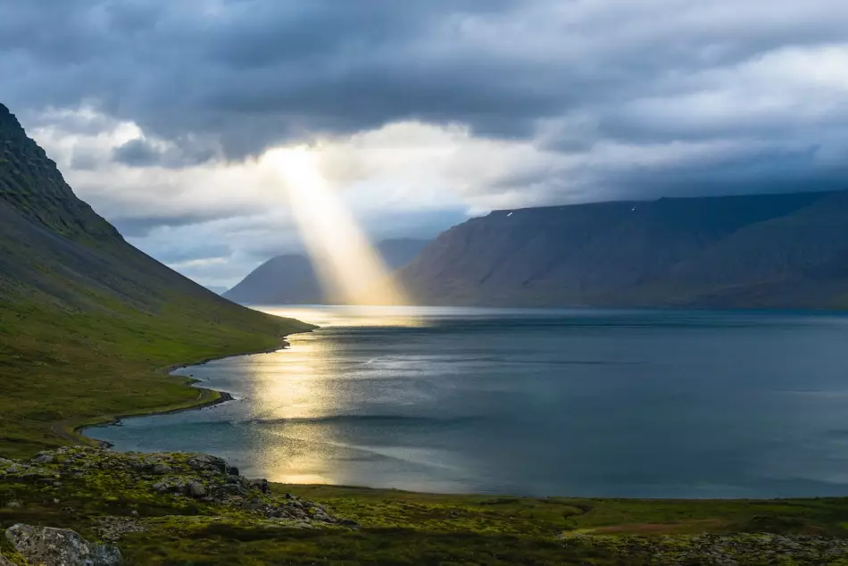 Paysage magique d'un fjord islandais avec le soleil transperçant les nuages