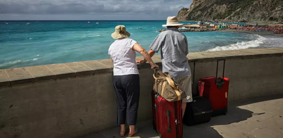 Couple de voyageurs en bord de mer avec ses valises