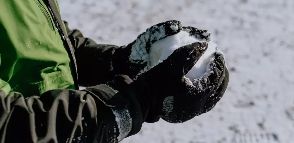 Homme tenant dans ses mains une boule de neige