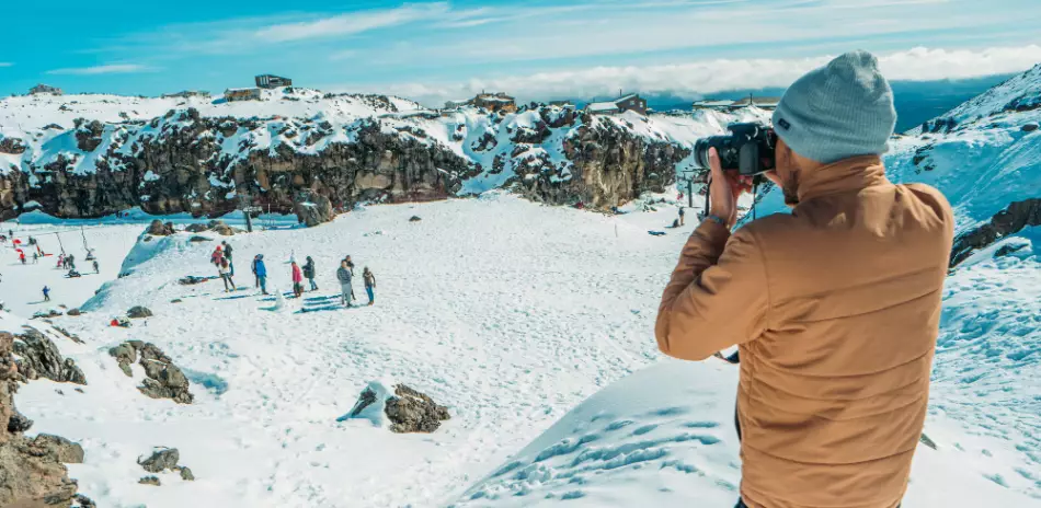 Un homme photographie groupe au milieu de la neige