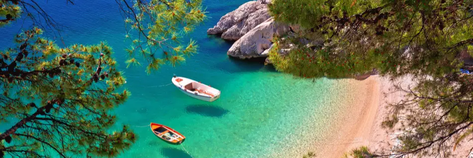 Plage de Hiden à Brela avec des bateaux sur la mer émeraude, riviera de Makarska en Dalmatie, Croatie