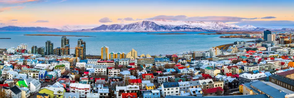 Panorama aérien du centre-ville de Reykjavik au coucher du soleil avec des maisons colorées et des montagnes enneigées en arrière-plan, Islande