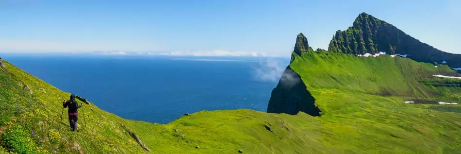 Un randonneur descendant sur le sentier le long des falaises de Hornbjarg, réserve naturelle de Hornstrandir, Westfjords, Islande