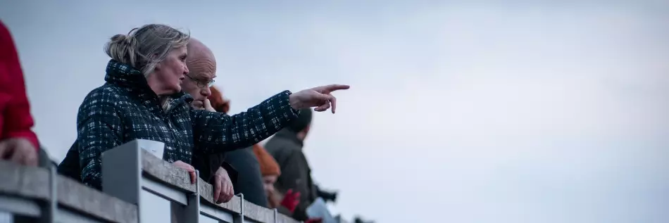 Couple pointant du doigts un bateau de croisière au loin