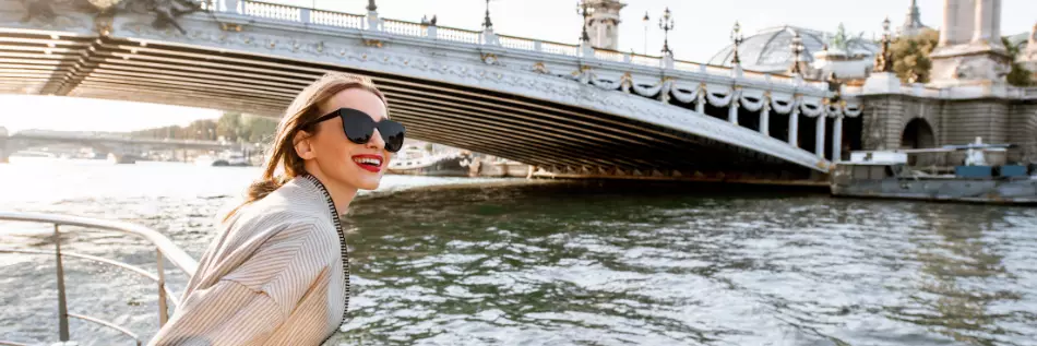 Jeune femme bénéficiant d'une belle vue sur le paysage depuis le bateau touristique au coucher du soleil à Paris