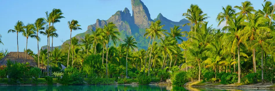 Vue sur la montagne du Mont Otemanu réfléchissant dans l'eau au coucher du soleil à Bora Bora, Polynésie française, Pacifique Sud