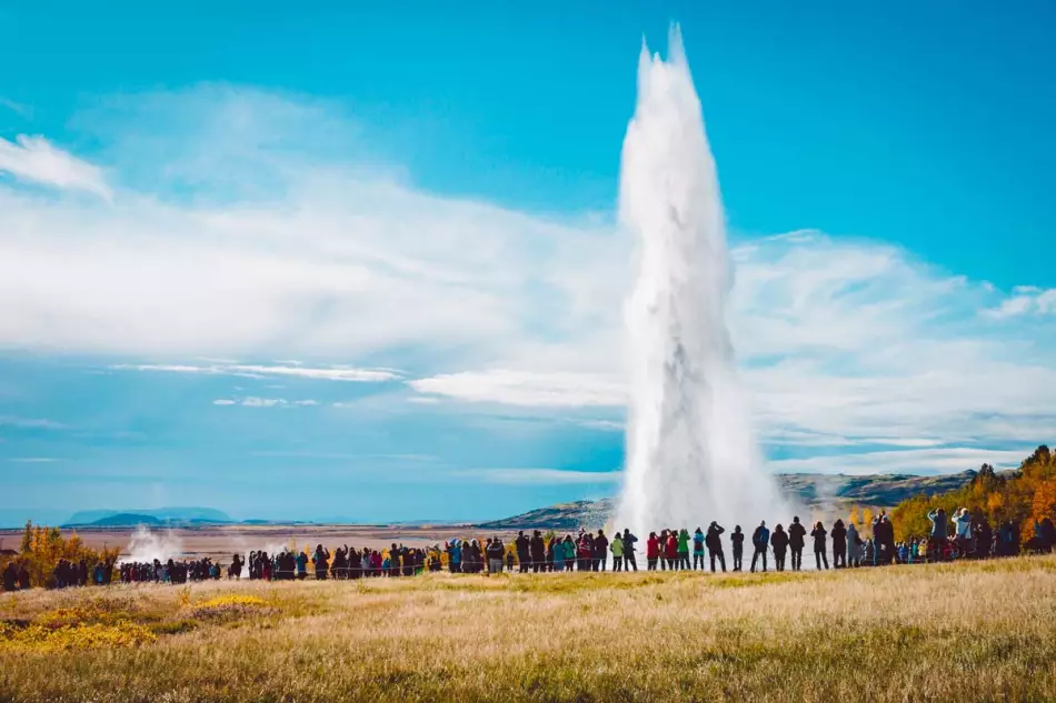 La foule de touristes admirant le spectacle d'un geyser en Islande durant l'été