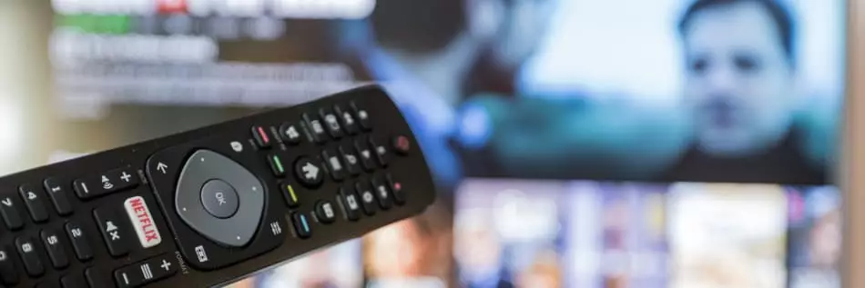 télécommande pour télévision en face de l'écran allumé