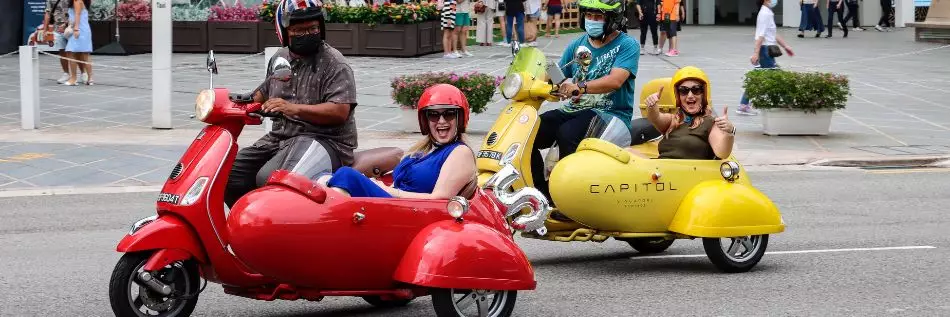 Les touristes profitant d'une visite guidée de la ville de Singapour en sidecar