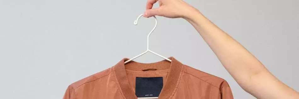 Veste à manches longues marron sur un cintre blanc