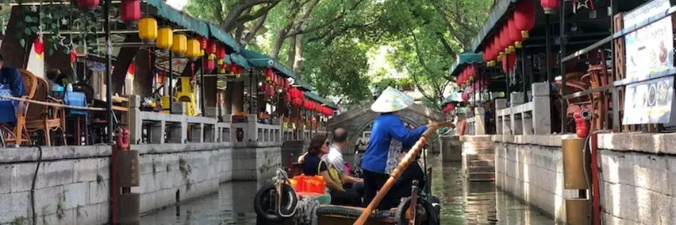 Une personne conduisant un bateau sur un canal dans la ville de Suzhou en Chine